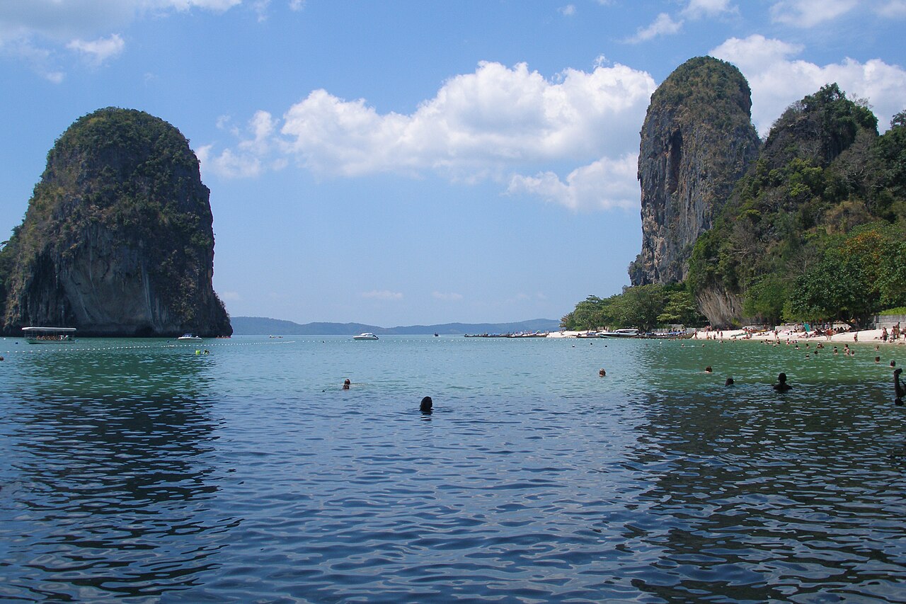Longtail boats moored on a turquoise beach in Krabi, Thailand