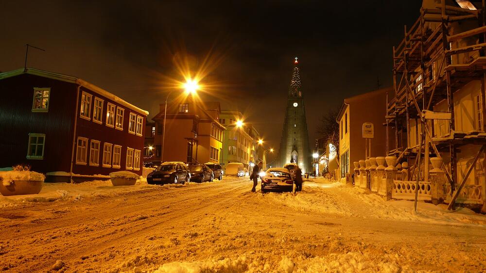 Snowy street in Reykjavík at night with Hallgrímskirkja behind, in January